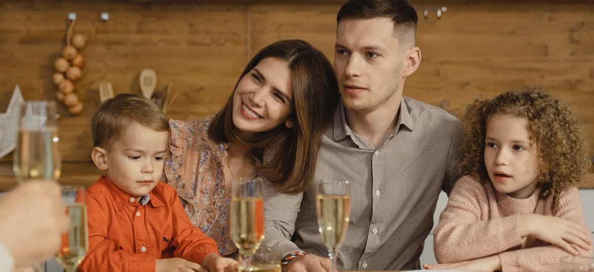 A joyful family gathers for a festive dinner, exchanging warmth and togetherness.