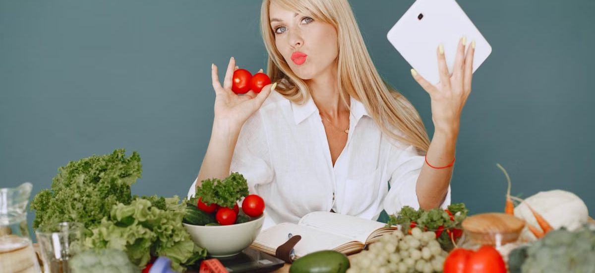 Vlogger promoting healthy eating with fresh vegetables on the table.